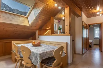 a dining room with a table and chairs and a skylight at DolomiApartments - Casa Lagorai in Predazzo