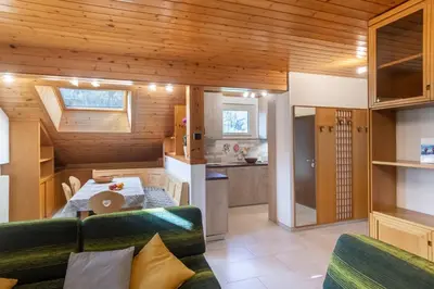 a kitchen and living room with a couch and a table at DolomiApartments - Casa Lagorai in Predazzo
