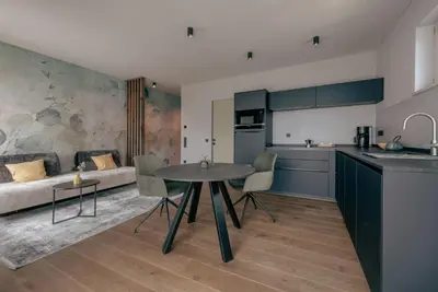 a kitchen and living room with a table and a couch at LA LIBELLA - slow living Suites in Merano