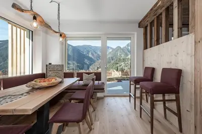 a dining room with a table and chairs and a large window at Hinterscholerhof in Lazfons