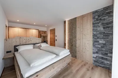 a bedroom with a large bed with white sheets at Hinterscholerhof in Lazfons