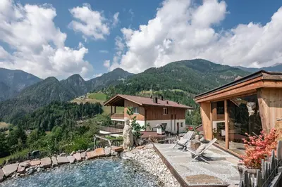 a house with a swimming pool in the mountains at Hinterscholerhof in Lazfons
