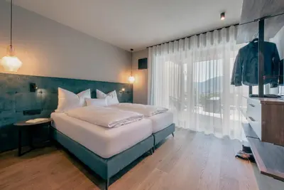 a bedroom with a large bed and a window at La Libella - Suite #5 - la terrazza mit privatem Pool in Merano