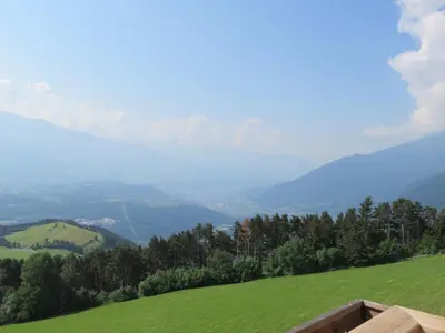 a green hill with a view of a valley at Parleitnerhof Ferienwohnung Morgenrot in Mühlbach