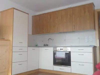 a kitchen with white cabinets and an oven at Parleitnerhof Ferienwohnung Morgenrot in Mühlbach
