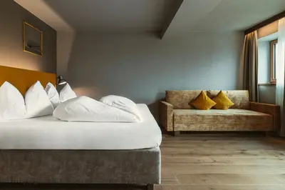 a hotel room with a bed and a couch at Hosler in Merano
