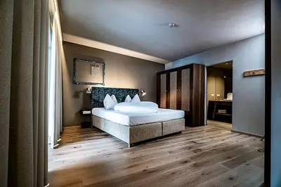 a bedroom with a bed and a large window at Hosler in Merano