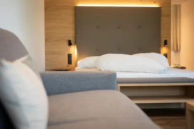 a bedroom with a bed and a chair at Natur Residence Kaiser Hans in Schenna