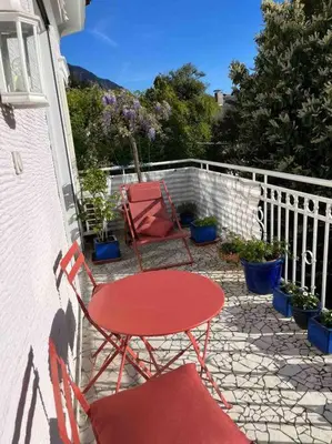 a red table and two chairs on a patio at Laurelia Suites in Merano