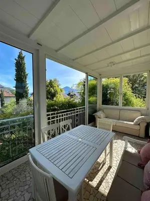 a screened in porch with a table and chairs at Laurelia Suites in Merano