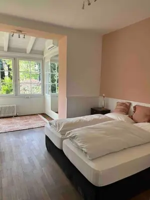 a large bedroom with two beds and a window at Laurelia Suites in Merano