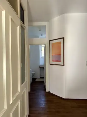 a hallway with white walls and a picture on the wall at Laurelia Suites in Merano
