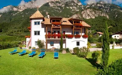 a group of chairs on a lawn in front of a house at Santlhof-Chardonnay in Cortaccia