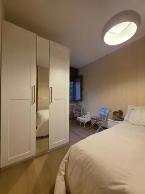 a bedroom with a bed and a large white cabinet at Hope Home Trentino in San Martino di Castrozza