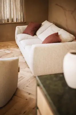 a couch sitting on a wooden floor in a room at Milla Apartments in Bressanone