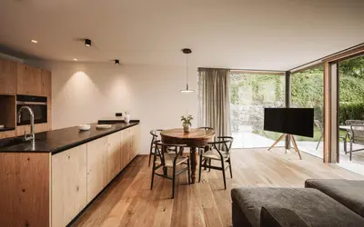 a kitchen and living room with a table and chairs at Milla Apartments in Bressanone