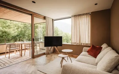 a living room with a couch and a large window at Milla Apartments in Bressanone