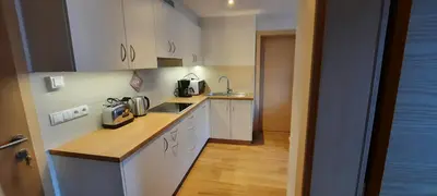a small kitchen with white cabinets and a sink at Pixnerhof Urlaub auf dem Bauernhof in Schenna