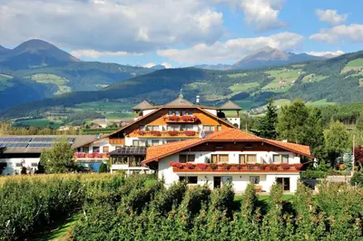 a house in a vineyard with mountains in the background at Stoanpeppelehof in Naz-Sciaves