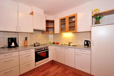 a kitchen with white cabinets and white appliances at Stoanpeppelehof in Naz-Sciaves