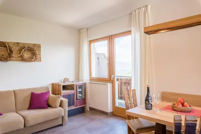 a bedroom with a large bed with a wooden headboard at Dissertorihof in Caldaro