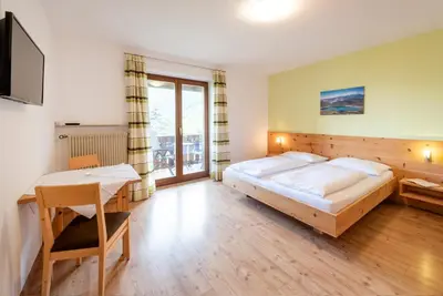 a bedroom with a large bed and a desk in it at Eich-hof in Caldaro