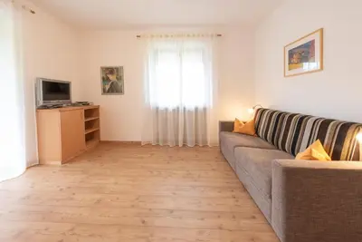a living room with a couch and a television at Eich-hof in Caldaro