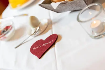 a table with a heart napkin and a spoon at Eich-hof in Caldaro