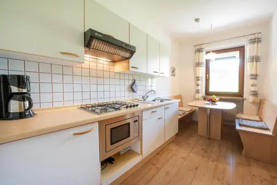a kitchen with white cabinets and a stove top oven at Eich-hof in Caldaro