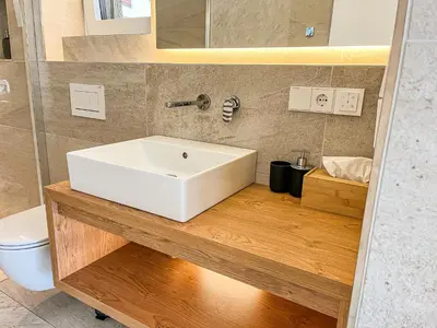 a bathroom with a white sink and a toilet at Garden Apartment Untermühle in Bressanone