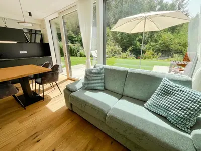 a living room with a couch and an umbrella at Garden Apartment Untermühle in Bressanone