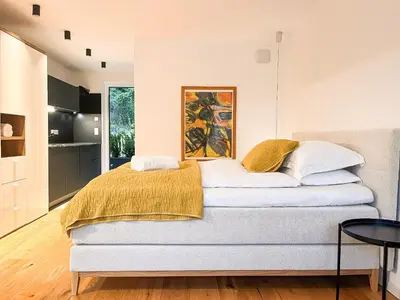 a bedroom with a bed with a yellow blanket on it at Garden Apartment Untermühle in Bressanone