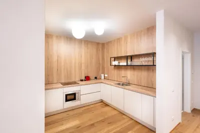a kitchen with white cabinets and wooden walls at Odilia - Historic City Apartments - center of Brixen in Bressanone