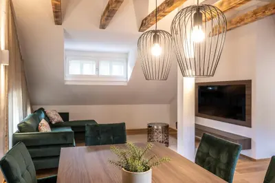 a living room with a table and chairs and two chandeliers at Odilia - Historic City Apartments - center of Brixen in Bressanone