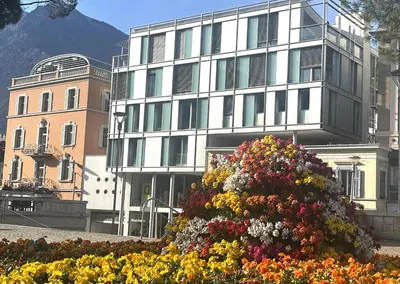 a large flower bush in front of a building at Kurhaus Apartment + parking in Merano