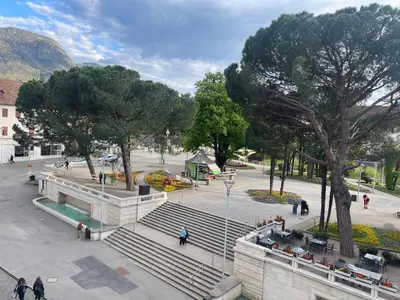 a group of people walking around a plaza with stairs at Kurhaus Apartment + parking in Merano