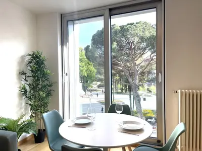 a white table and chairs in a room with a window at Kurhaus Apartment + parking in Merano