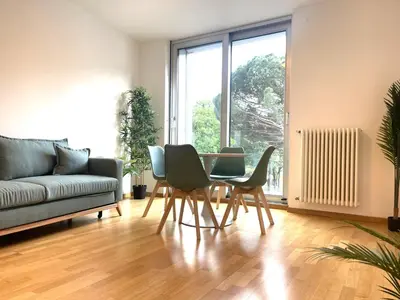 a living room with a table and chairs and a couch at Kurhaus Apartment + parking in Merano