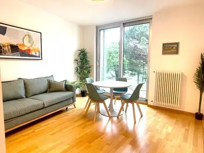 a living room with a couch and a table and chairs at Kurhaus Apartment + parking in Merano