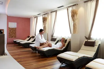 a man and a woman sitting in chairs at Hotel Carmen Dolomites in Santa Cristina in Val Gardena
