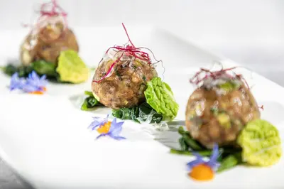 a white plate with a dish of guacamole at Hotel Carmen Dolomites in Santa Cristina in Val Gardena