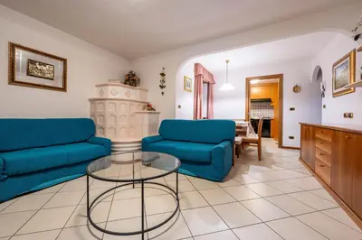 a living room with two blue couches and a table at Majon Fior de Bosch 2 in Campitello di Fassa