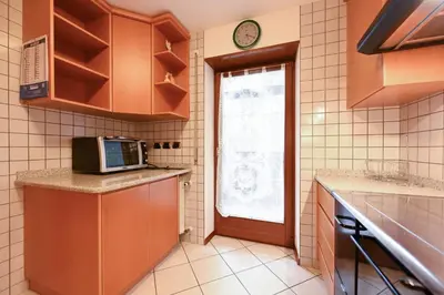 a kitchen with a microwave and a window at Majon Fior de Bosch 2 in Campitello di Fassa