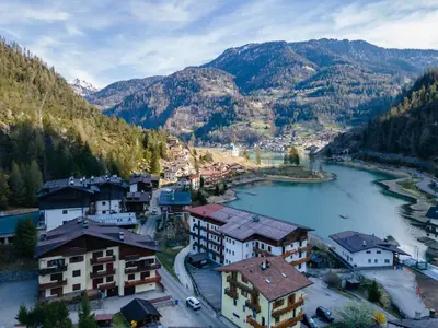 an aerial view of a town with a river and mountains at Abetaia sul Lago in Alleghe
