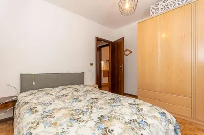 a bedroom with a bed and a wooden cabinet at Abetaia sul Lago in Alleghe