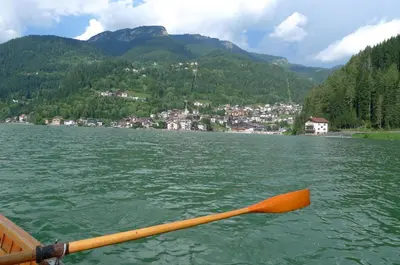 a paddle in a boat on a lake with a town at Abetaia sul Lago in Alleghe