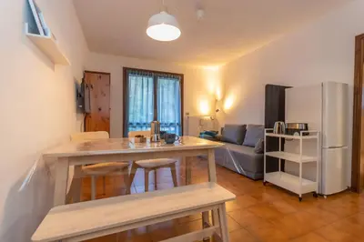 a kitchen and living room with a counter and a refrigerator at Abetaia sul Lago in Alleghe