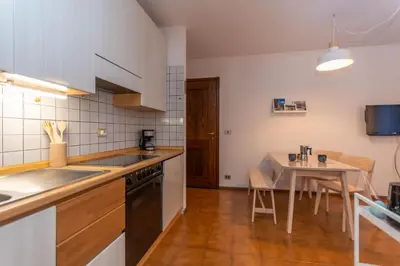 a kitchen with a sink and a table with a dining room at Abetaia sul Lago in Alleghe