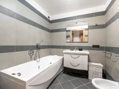 a bathroom with a white tub and a sink at Apartment Condominio Giulia by Interhome in Alba di Canazei