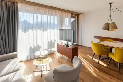 a living room with a couch and a tv and a table at Apartments by Bemelmans-Post in Collalbo